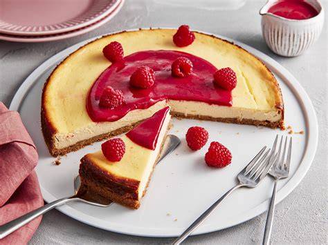 Himbeer Cheesecake auf weißem Teller mit frischen Himbeeren