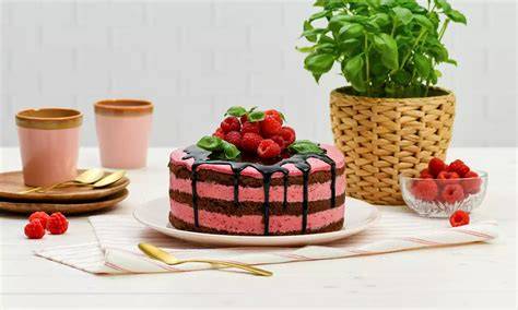 Himbeer-Basilikum-Torte, fertig dekoriert mit Basilikum und Beeren