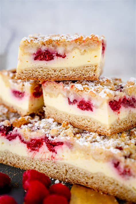 Himbeer-Quark-Kuchen mit Streuseln auf rustikalem Brett, Zutaten drumherum