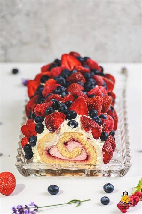 Himbeercreme, Sahne und frische Beeren als Füllung einer Biskuitrolle