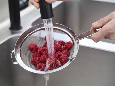 Himbeeren im Sieb abtropfen
