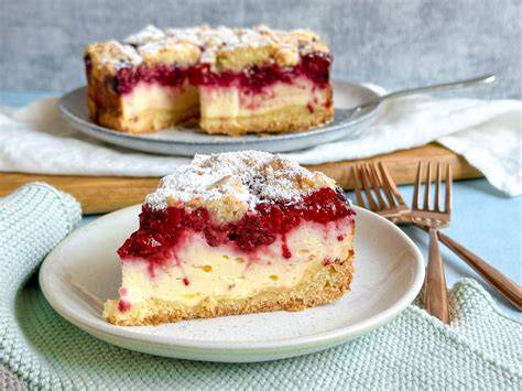 Himbeerkuchen fertig dekoriert mit Sahnetupfen und Baiser