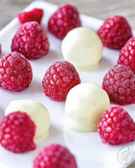 Himbeerpralinen mit weißer Schokolade auf Holzbrett