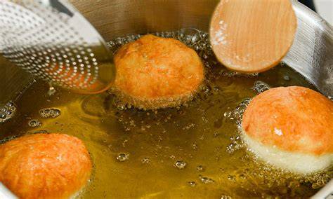 Historische Darstellung von Klostermönchen beim Backen von Krapfen