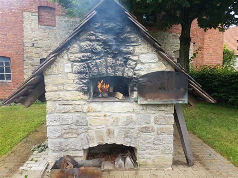 Historischer Holzbackofen und Bäcker im Dorf