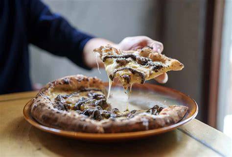 Hobel frisch gehobelten Trüffel über Pizza