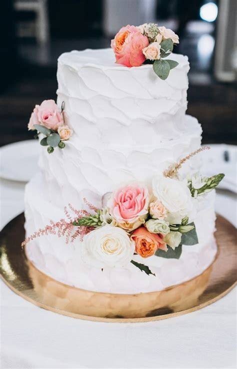 Hochzeitstorte mit Blumen und Tortenfigur dekoriert