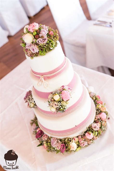 Hochzeitstorte mit Fondant, essbaren Blumen und Brautpaar-Figur