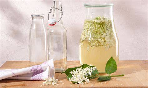 Holunderblüten im Glas und Sirup abfiltern