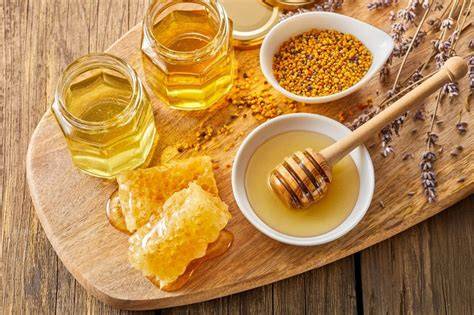 Honig und Puderzucker auf Holzbrett