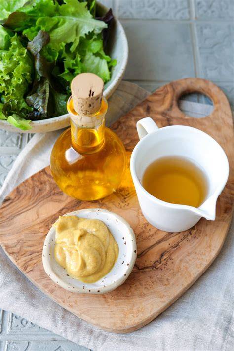 Honig-Senf-Dressing Zutaten auf einem Holzbrett