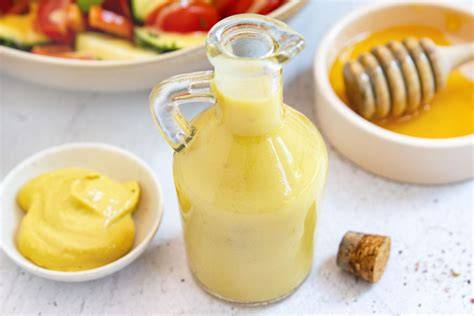 Honig-Senf-Dressing Zutaten in Schüssel mit Olivenöl und Honig