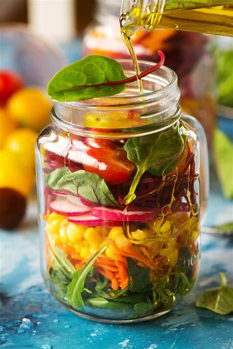 Honig-Senf-Dressing in einem Glas und daneben frischer Salat