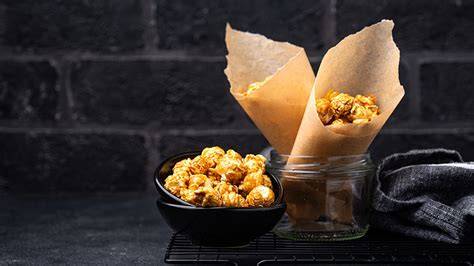 Honigkaramell, das über Popcorn gegossen wird