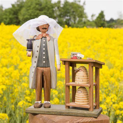 Imker mit Bienenkörben auf einer Wiese