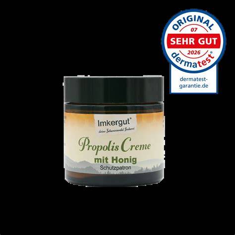 Imkergut Propolis Creme, grob aufgemacht, neben Honig, Bienenstock und Propolis-Brocken