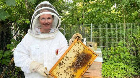 Imkerin Annika Singer mit Bienenvolk und Honigglas