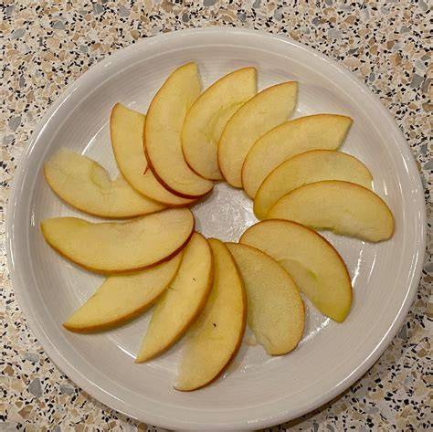 In Scheiben geschnittene Äpfel auf Kuchenboden verteilen