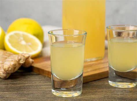 Ingwersirup auf dem Küchentisch mit frischem Ingwer