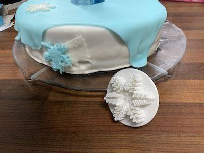 Isomalt Eisberge und Fondant-Schneeflocken auf blauer Torte