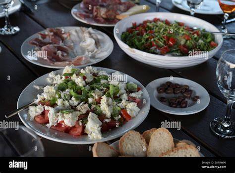 Italienische Steinofenpizza und mediterrane Antipasti auf einem rustikalen Tisch
