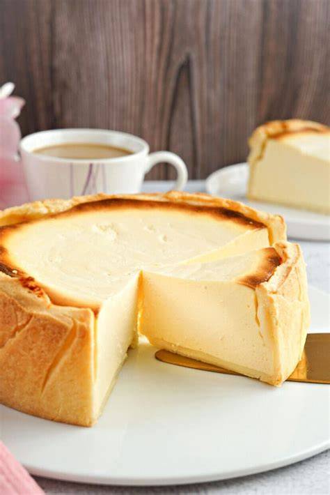 Italienischer Käsekuchen aufgedeckt, angeschnitten, Kaffeetasse, Sommerambiente