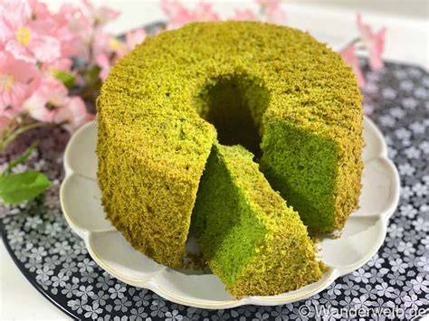 Japanischer Matcha-Chiffon-Kuchen auf einer Platte, umgeben von Teezubehör