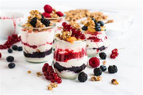 Joghurt-Desserts im Glas mit Beeren, Nüssen und Keksstückchen