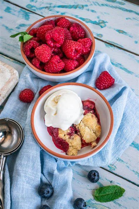 Joghurteis in Schale neben Crumble