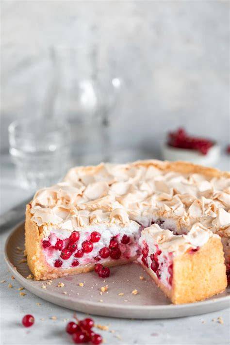 Johannisbeer-Baiser-Kuchen auf einem Kuchenteller mit Frucht-Dekor