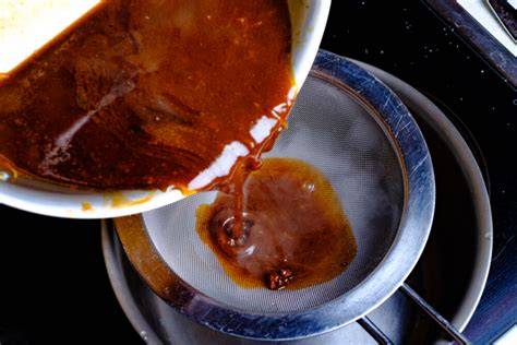 Johannisbeersauce im Sieb passieren