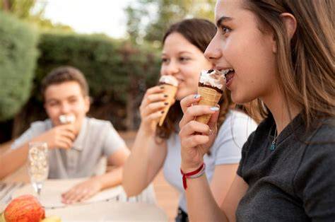 Jugendliche beim gemeinsamen Pudding-Essen im Freien