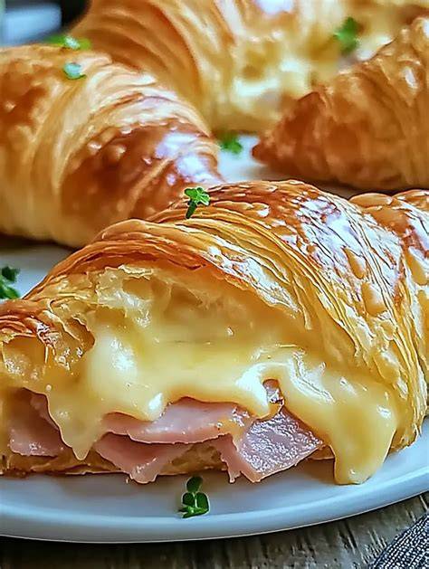 Käse-Schinken-Croissants frisch aus dem Ofen auf einem Holzbrett