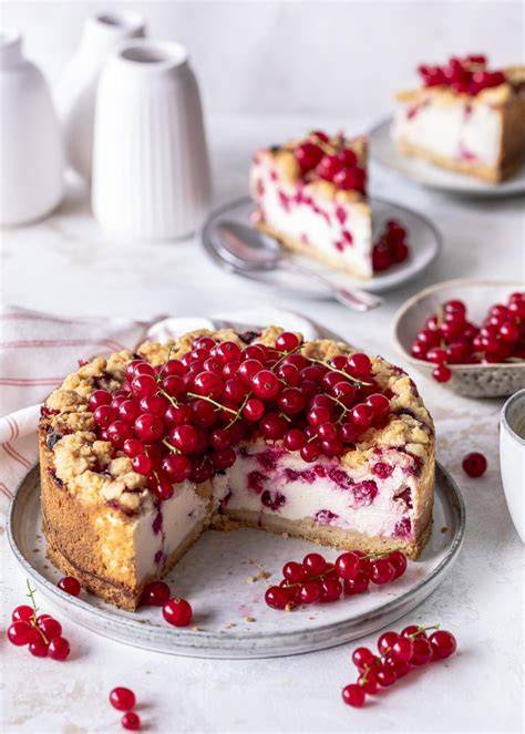 Käsekuchen besteckt mit frischen Johannisbeeren