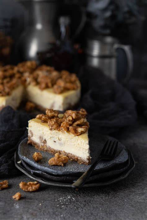 Käsekuchen mit Ahornsirup und Walnuss - angeschnitten und auf Teller serviert