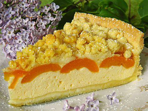 Käsekuchen mit Aprikosen und Streuseln auf Kaffeetisch