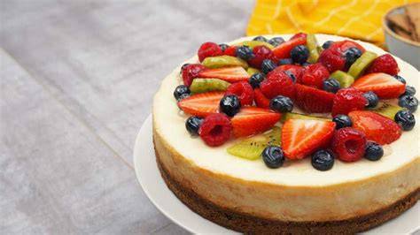 Käsekuchen mit Biskuitboden, Dekoration mit frischen Früchten