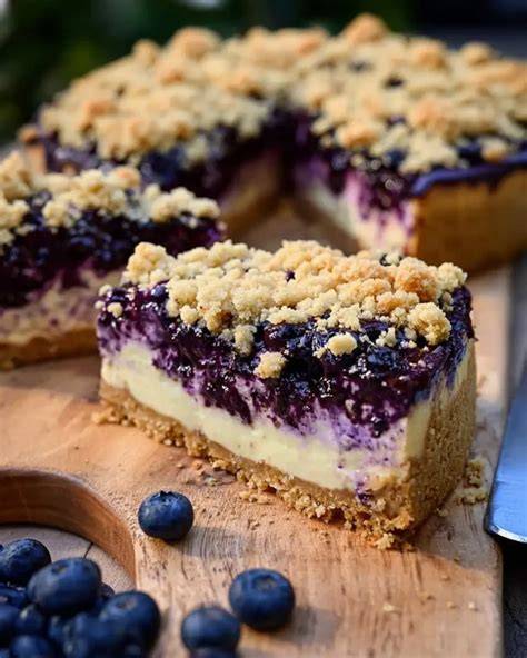 Käsekuchen mit Blaubeeren aufgeschnitten, Blaubeeren und Streusel sichtbar
