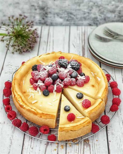 Käsekuchen mit Puderzucker und Beeren