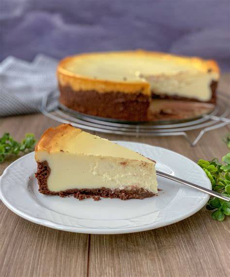 Käsekuchen mit Schokoboden und Schokoladensoßen marmoriert serviert