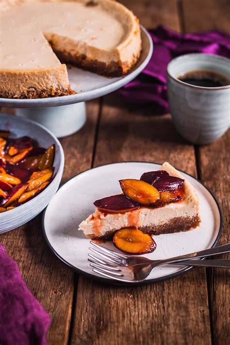 Käsekuchen mit karamellisierten Nüssen - angeschnittener Kuchen auf einem Holztisch
