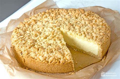 Käsekuchen mit knusprigen Streuseln angeschnitten auf einem Holzbrett