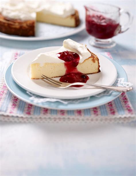 Käsekuchen mit roter Grütze angerichtet auf Tellern
