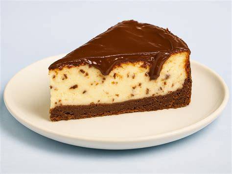 Käsekuchen-Stücke mit Schokoguss und Puderzucker auf Servierplatte