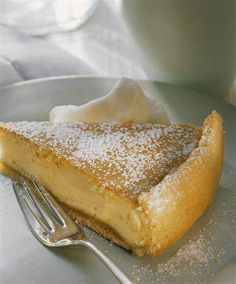 Käsekuchenstück mit Gabel auf Tellerrand