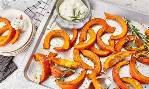 Kürbisspalten auf Backblech, vorbereitet zum Backen mit Chiliöl