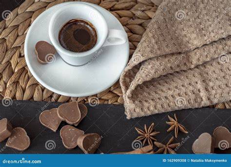 Kaffeetasse mit Stück Schokolade auf dem Unterteller