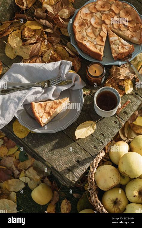 Kaffeetisch mit Apfel-Karamell-Schnecken, Tee und herbstlichen Äpfeln