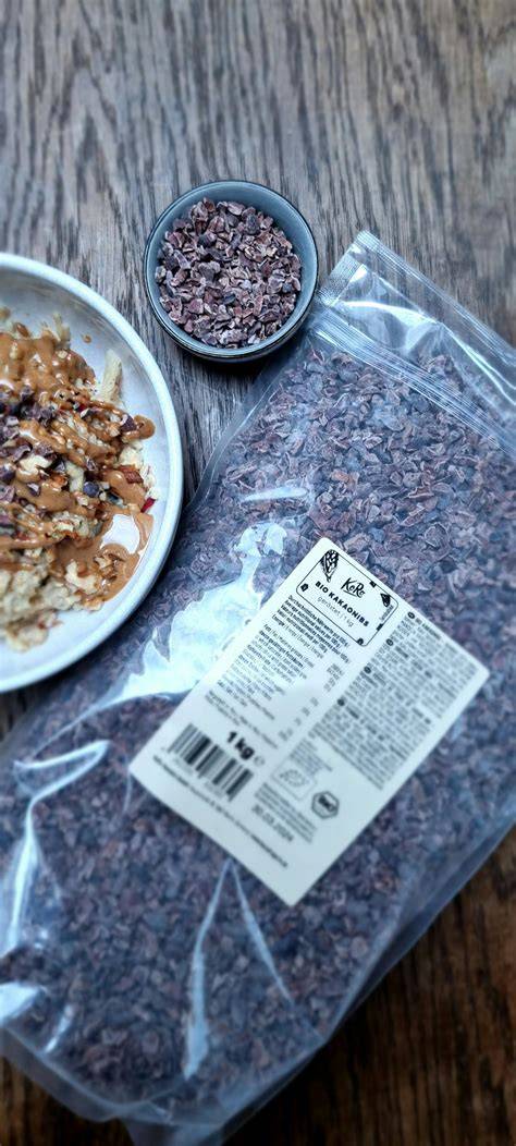 Kakaonibs, Kokosblütenzucker und Gewürze neben Erdnussbutter
