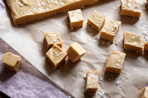 Karamell Fudge Stücke auf Holzbrett mit Meersalz bestreut